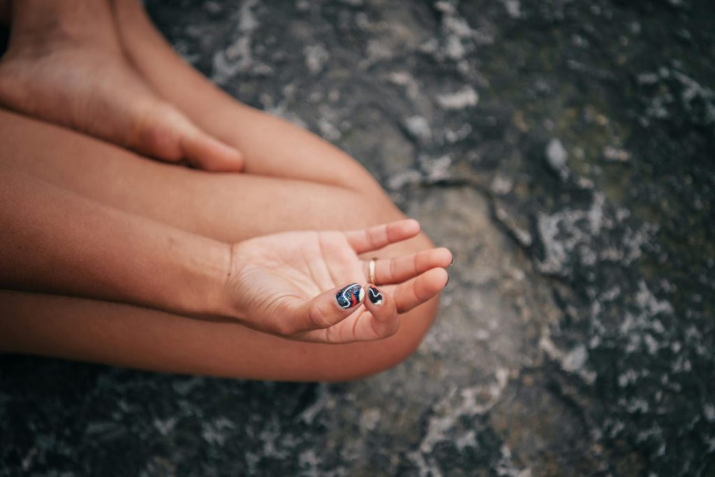 Close-up of a hand in gyan mudra, symbolizing peace and mindfulness during meditation.