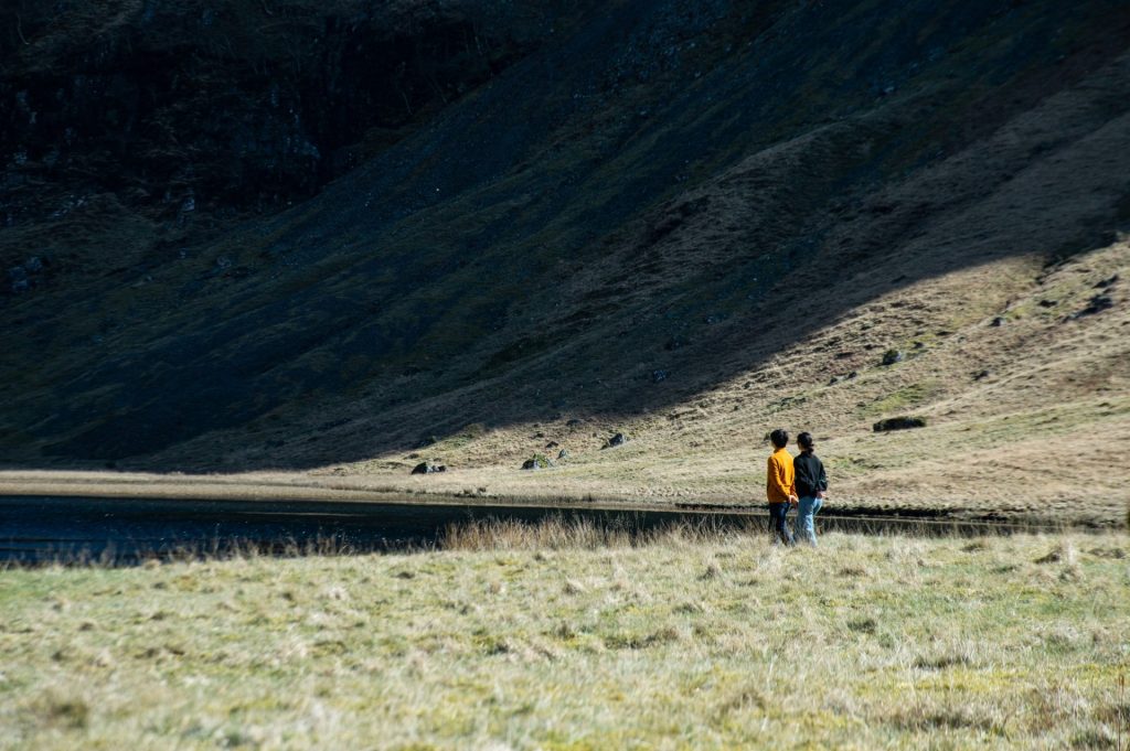 a couple of people that are standing in the grass